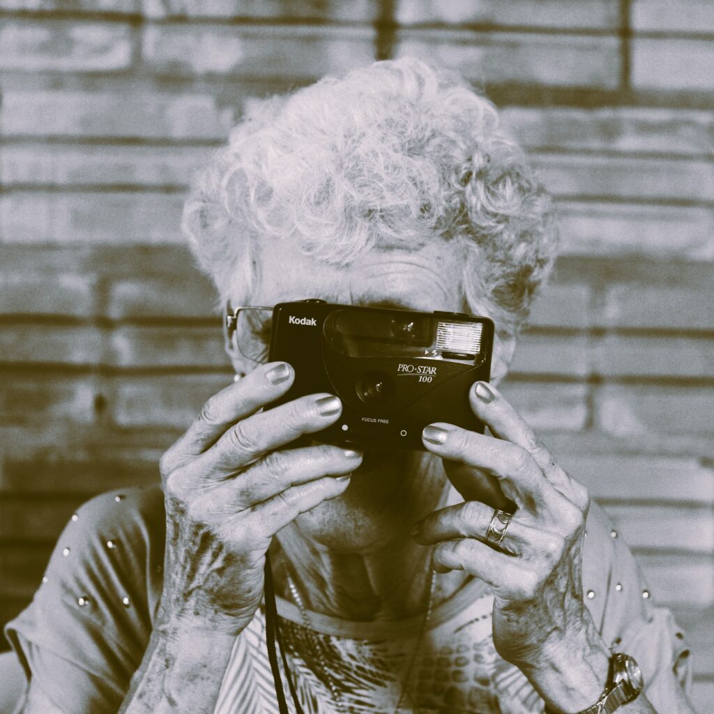 Formule 2 : les mémoires de vie. Une personne plus âgée prend une photo pour revenir sur un parcours de vie plus long.